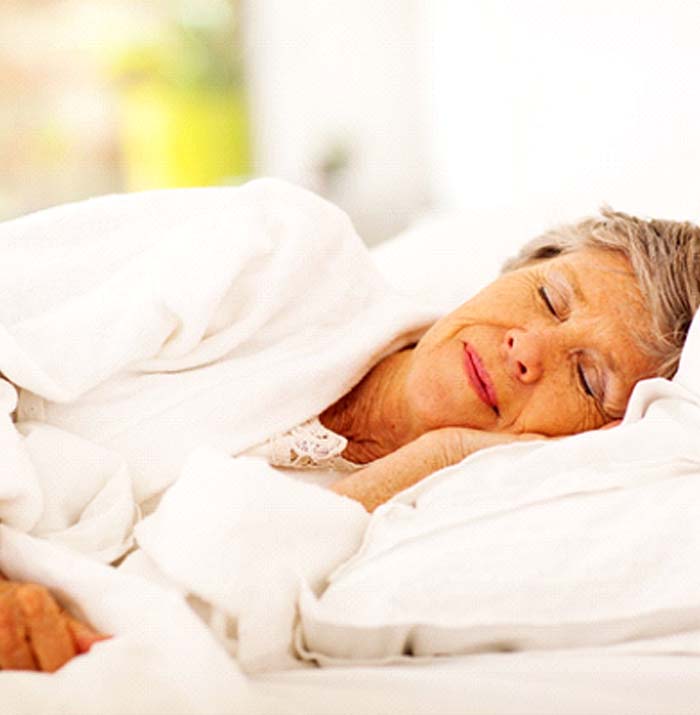 Older woman with dental implants in Kansas City sleeping