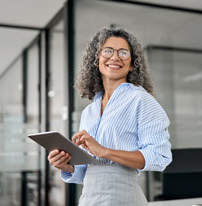 Woman smiling while holding tablet in office
