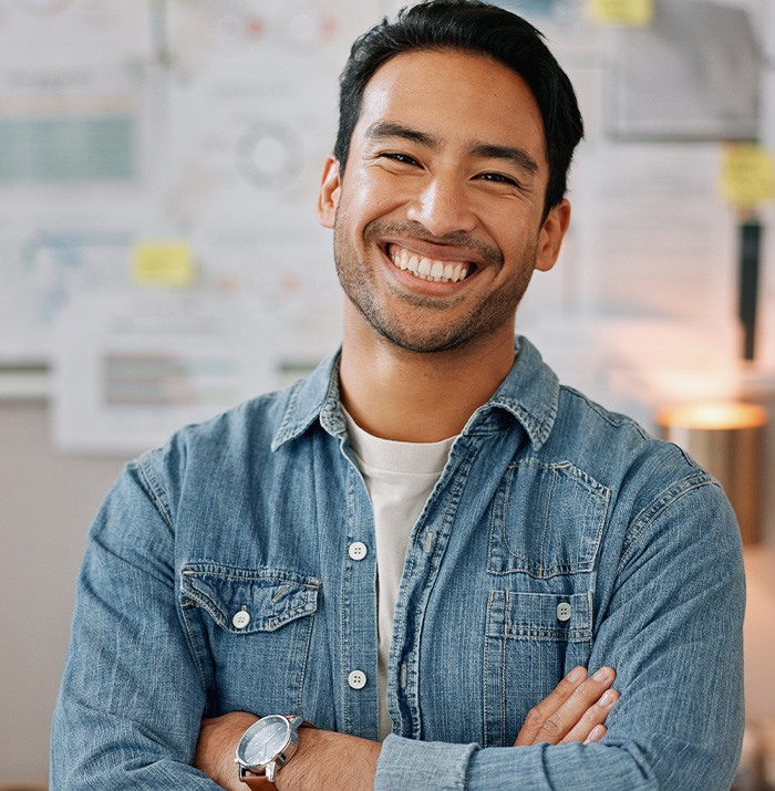 Man in denim shirt smiling in office