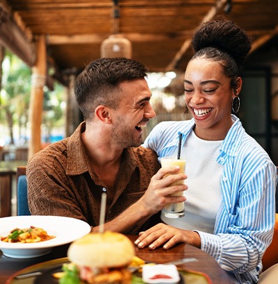 Couple smiling while enjoying meal in restaurant