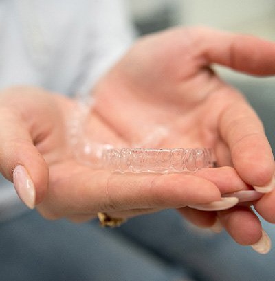 Closeup of patient holding clear aligners