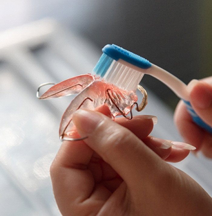 Gently cleaning orthodontic retainer to get rid of bacteria