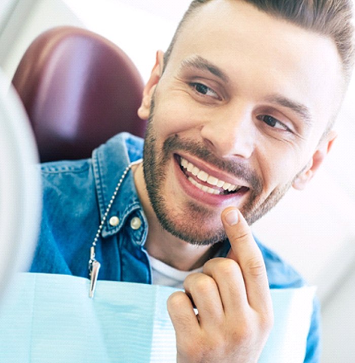 Man admiring his smile after Invisalign treatment in Kansas City