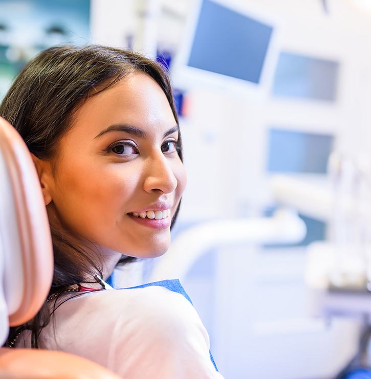 A beautiful, smiling woman sitting in a dentist chair
