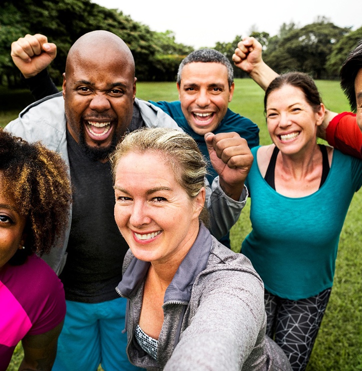 Group of happy adults outside smiling taking selfie together