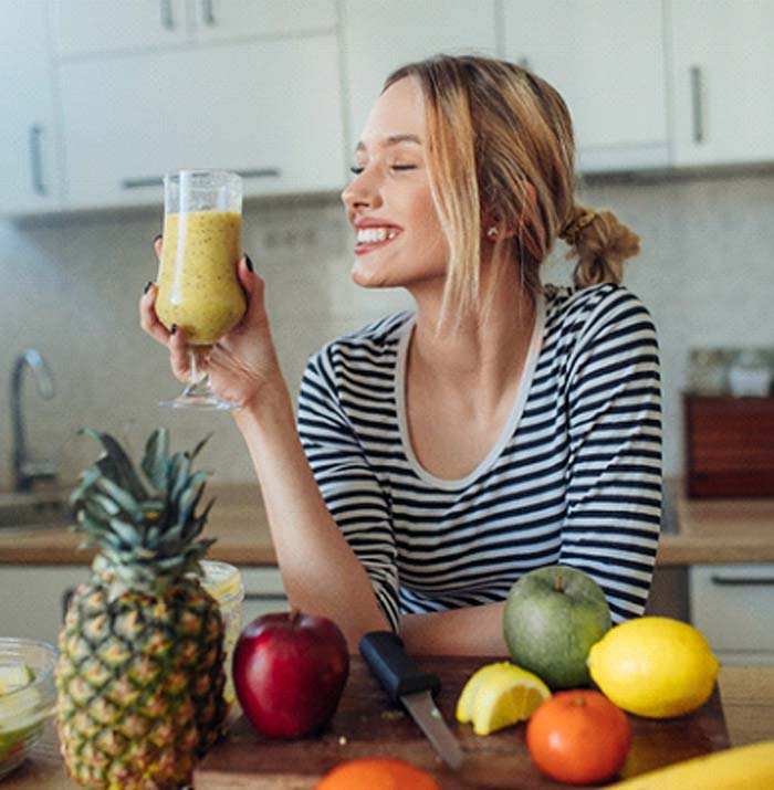 Woman holding a smoothie and smiling