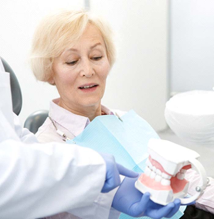 Woman learning dental implant post-op instructions in Kansas City