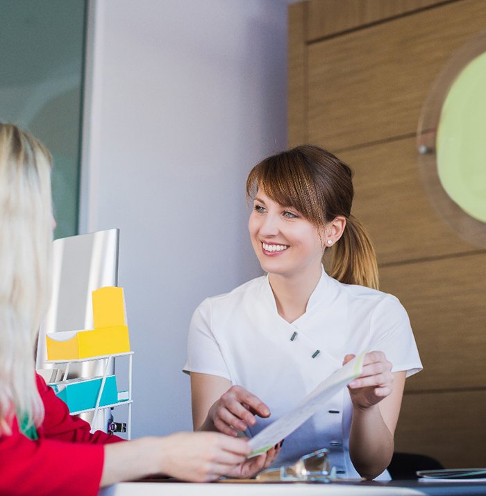 dental team member showing paperwork to a patient