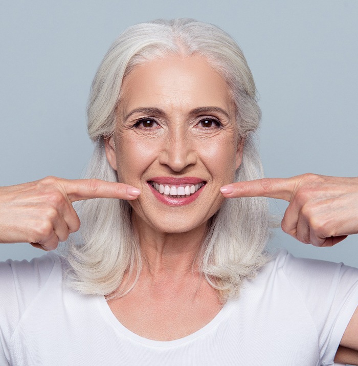 woman pointing to her smile