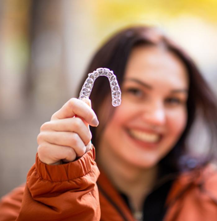 Clear orthodontic aligner on purple background. 