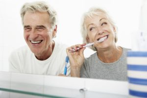 senior couple laughing brushing teeth