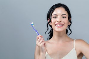 Smiling woman with beautiful smile holding sanitized toothbrush