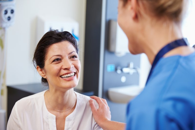 Dentist explaining to patient how dental implants improve confidence