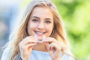 teen girl inserting Invisalign in Kansas City