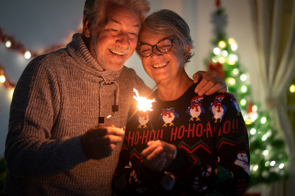 older couple lighting holiday candles smiling