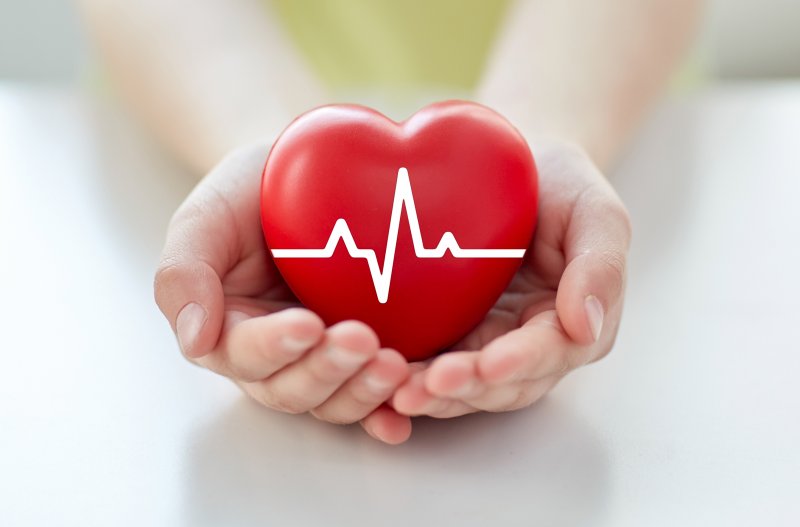 Person holding heart model for Heart Health Month