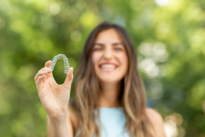 a patient holding her Invisalign aligner