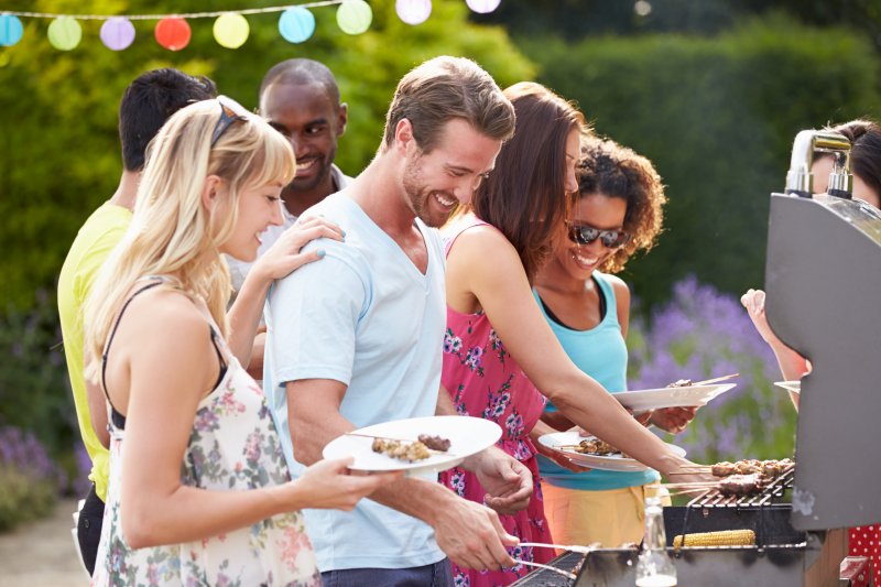 People smile at barbeque.