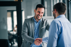 two people smiling and shaking hands 