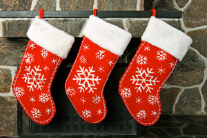 Three Christmas stockings hung over a fireplace