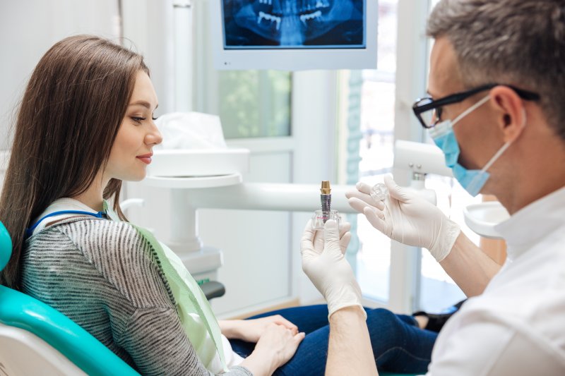 A dentist talking to his patient about dental implants