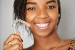 Young woman holding a clear aligner