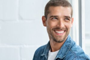 Man smiling after getting a cosmetic dental treatment